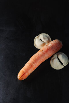 Carrots and dumplings on a black background. Silhouette of a dick