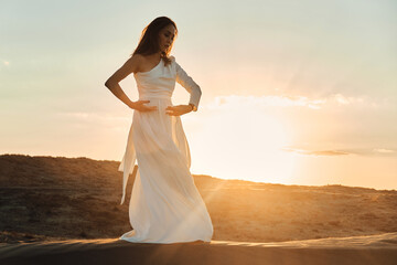 Fototapeta na wymiar Dances in the desert in white dress