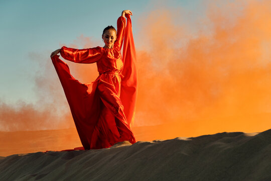 Woman In Red Dress Dancing In The Desert