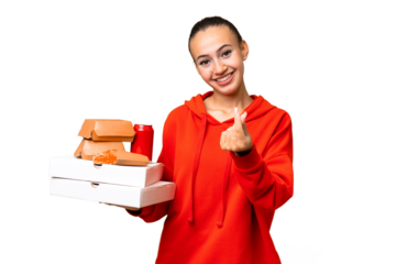Young Arab woman holding fast food over isolated background making money gesture