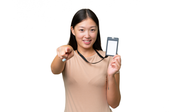 Young Asian woman with ID card over isolated background points finger at you with a confident expression