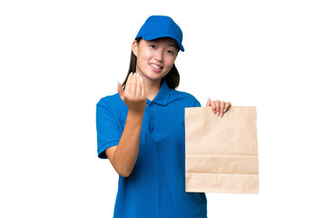 Young Asian woman taking a bag of takeaway food over isolated background inviting to come with...