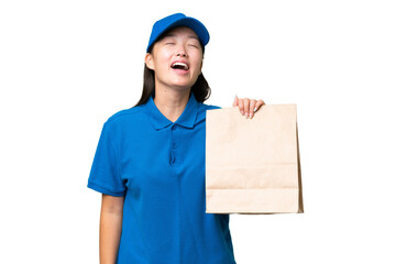 Young Asian woman taking a bag of takeaway food over isolated background laughing