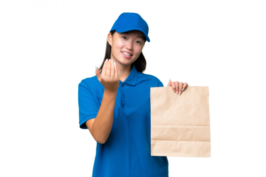 Young Asian woman taking a bag of takeaway food over isolated background inviting to come with hand. Happy that you came