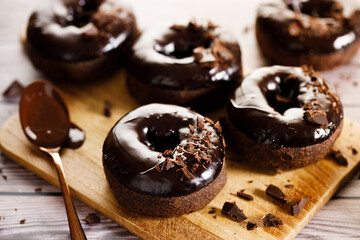 Chocolate donuts on wooden table background.