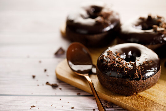 Chocolate donuts on wooden table background.