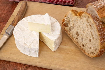 camembert coupé sur une planche en bois avec du pain