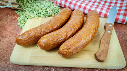 saucisses fumée et pois cassés sur une planche à découper	