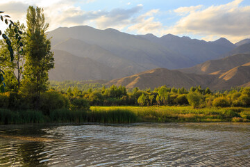 Lake in the mountains. Quiet bay in the greenery at sunset. Place for rest. Kyrgyzstan, Lake...