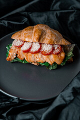 grilled salmon steak with tomato in croissant