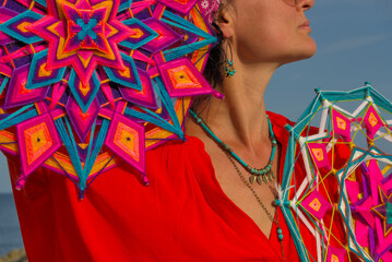 A woman holds in her hands a mandala made of multi-colored threads. Boho style clothes. On the...