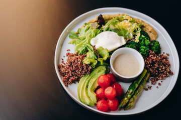A healthy bowl of quinoa, poached egg, asparagus, tomatoes, chickpeas and avocado. Restaurant service.