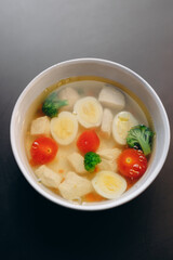 Chicken soup for children, with a boiled egg, chicken fillet, broccoli and tomatoes.