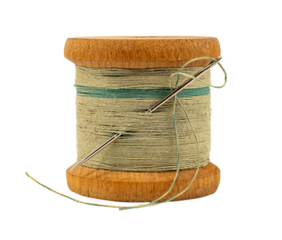 An old wooden spool of thread and a needle on a white background close-up. Threads for sewing