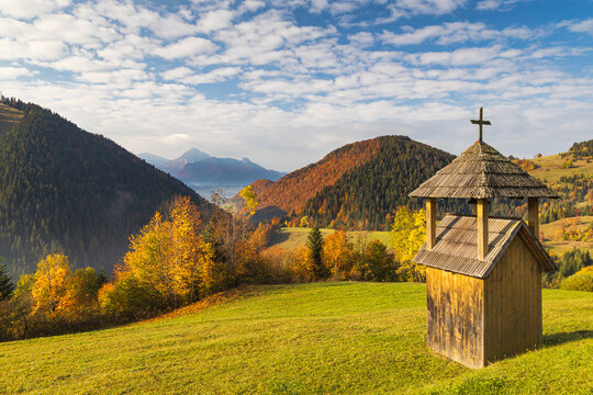 A small wooden bell tower in the foreground of a mountain landscape. Mala Fatra National Park, near the village of Zazriva in Slovakia, Europe