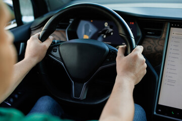 Close up of man hand on vehicle steering wheel as he is driving. Male driving a car in the highway, hands move on the wheel. Unrecognizable businessman putting his hands on steering wheel of car
