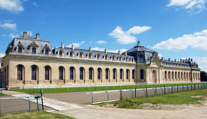 Fototapeta na wymiar Les Grandes Ecuries, chef-d'oeuvre architectural du XVIIIe siècle, à proximité des pistes de l'hippodrome, domaine de Chantilly, Oise, France
