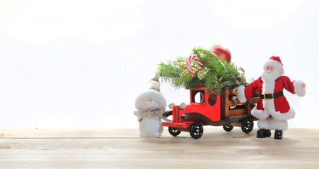 Christmas card composition, with a Christmas tree in the trunk of Santa Claus's car with a snowman,...