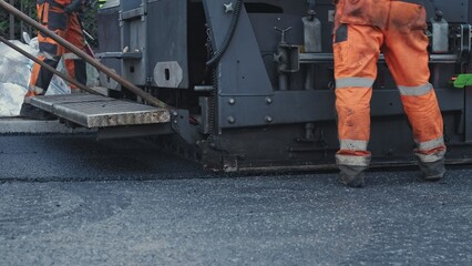 Fototapeta premium Road Paving Machine Roadworks Asphalt Laying Machine Operated by Workers Wearing Protective Workwear