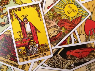 Picture of The Magician tarot card from the original Rider Waite tarot deck with mixed tarot cards in the background
