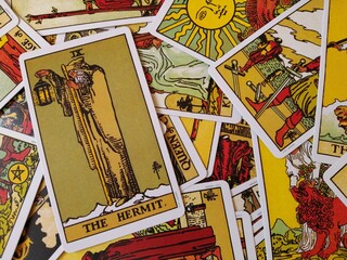 Picture of The Hermit tarot card from the original Rider Waite tarot deck with mixed tarot cards in the background