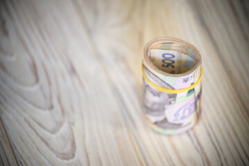 new Ukrainian hryvnia. 500 hryvnia on wooden table bind with rubber tape to tube. money background...