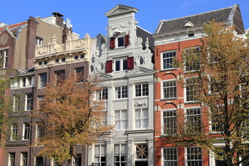 Fototapeta na wymiar Amsterdam Keizersgracht Canal Historic House Facades with Autumn Trees and Blue Sky, Netherlands