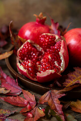 Ripe pomegranate fruits, still life with autumn leaves