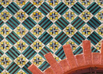 Streets of Lisbon. Detail of traditional facade decorated with colorful tiles and red brick arch. Portugal. 