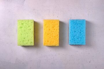 Multicolored sponges for washing dishes on a white background, top view