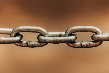 Close up chain links on sepia colored backdrop as old connection concept