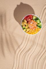 Hawaiian traditional food poke bowl on sand