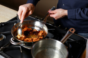 Chef prepares italian national bolognese sauce in kitchen