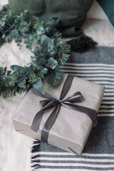 Stylish holiday background with wrapped gift box and Christmas wreath. Holiday concept.