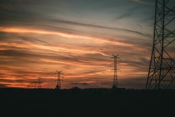 Silhouettes of transmission towers at sunset.