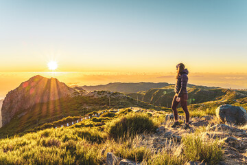 Woman enjoying beautiful mountain landscape of Pico do Ariero during sunrise. Pico do Arieiro,...