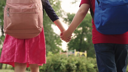 boy girl go school holding hands.students with backpacks their backs. child school friends with school bags rush lesson. hand hand close up. chidhood dream. happy schoolchildren park. kid school