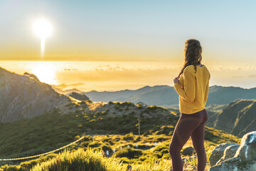 Woman enjoying beautiful mountain landscape of Pico do Ariero during sunrise. Pico do Arieiro,...