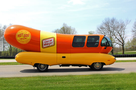 Plymouth, Wisconsin USA - May 27, 2019: Oscar Mayer's famous promotional wiener wagon is an icon of American advertising. This is a photo of a replica, driving on a rural road.