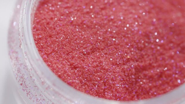 red sequins in a jar rotate in a circle