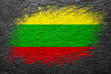 Flag of Lithuania. Flag is painted on a stone surface. Stone background. Black slate background