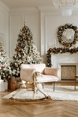 christmas decor. A Christmas tree in a beautifully decorated living room on the background of a fireplace. White interior.