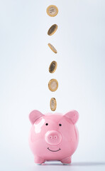 Isolated of coins dropping to pink piggy bank saving for deposit banking of investment , retirement...