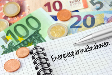 Finanzen und Energiesparmaßnahmen mit Buch und Euro Geldscheinen - obrazy, fototapety, plakaty