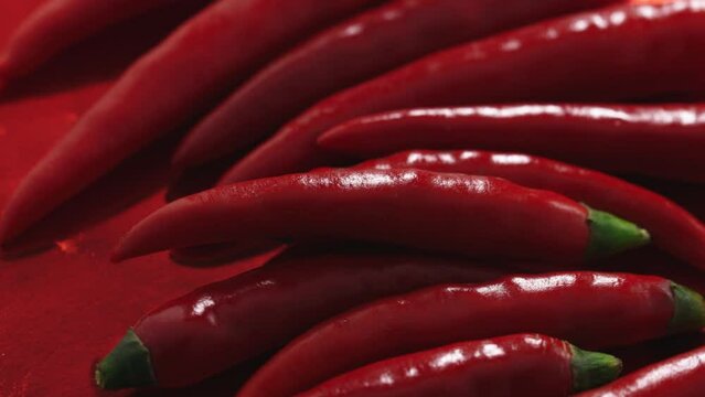 red chili peppers rotate in a circle on a red plate