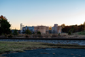 Sunset over industrial plant and rail road tracks