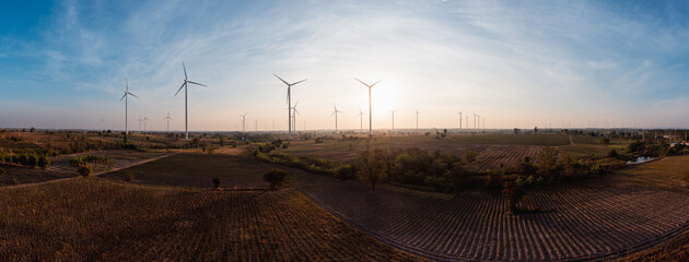 Aerial view of powerful wind turbine farm for pure energy production on beautiful sunset sun...