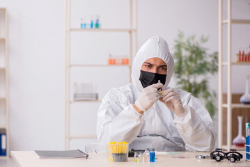 Young male chemist working at the lab during pandemic