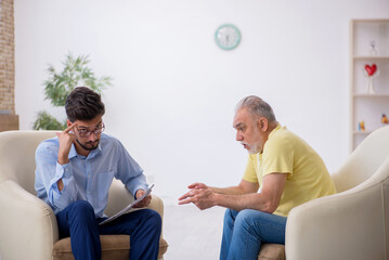 Old man visiting young male psychotherapist