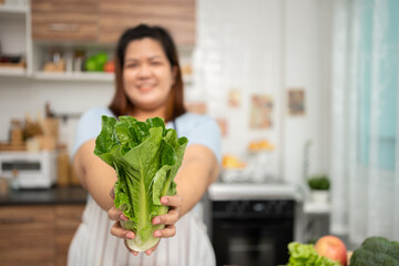 Asian Pregnant learn how to cook healthy meals from the Internet in kitchen, Fat women prepare a vegetable salad for diet food and lose weight. Concept of healthy eating